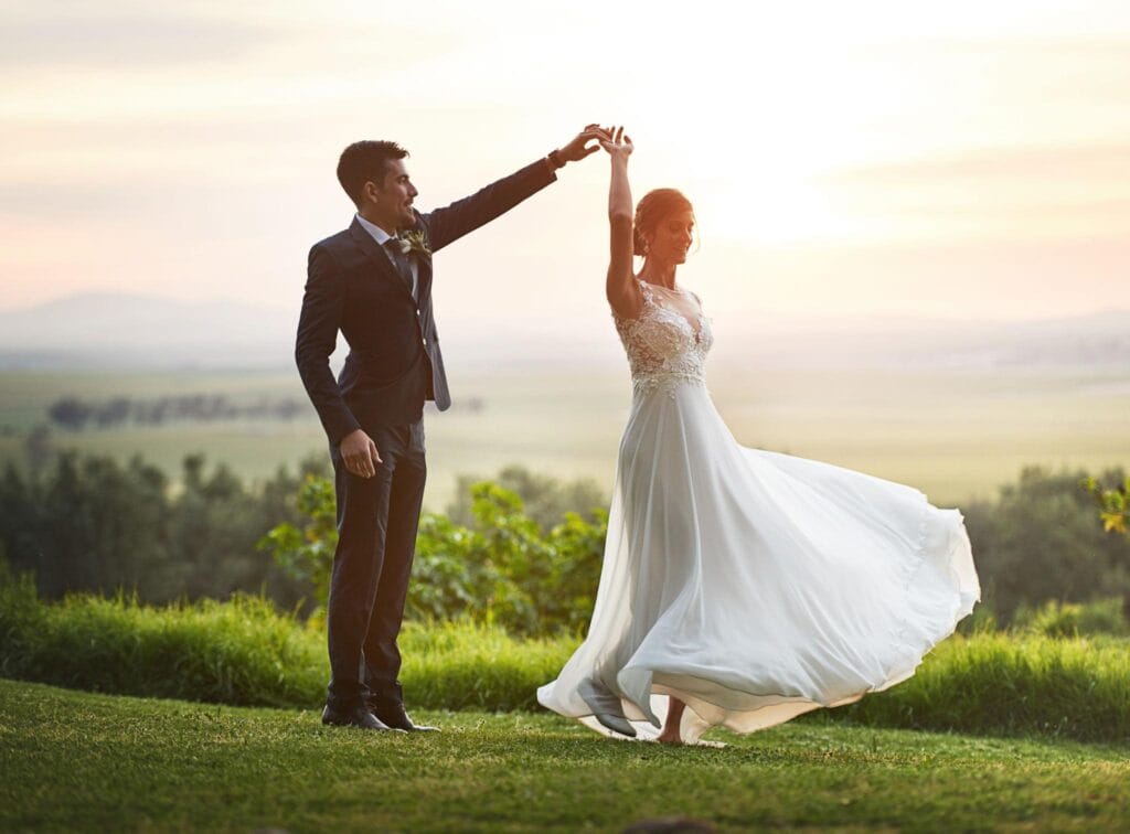 Bride and groom sharing a romantic sunset dance during their wedding day, capturing an emotional moment and unforgettable memory.