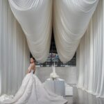 Elegant luxury wedding design featuring soft Cloud Dancer neutral tones, flowing ivory drapery, and a modern bridal aesthetic.