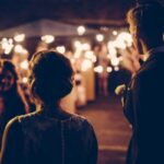 Bride and groom celebrating with guests during a modern sparkler wedding exit at an outdoor evening reception