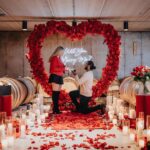 Romantic winery proposal surrounded by candlelight and red roses inside a luxury Niagara wine cellar