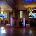 Luxury wedding reception setup with immersive lighting, video screens, and professional entertainment production at a modern wedding venue.