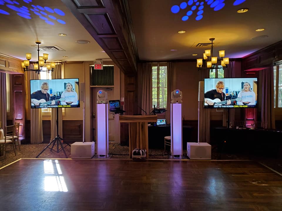 Luxury wedding reception setup with immersive lighting, video screens, and professional entertainment production at a modern wedding venue.