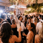 Guests celebrating on a vibrant luxury wedding dance floor with immersive lighting and energetic reception atmosphere