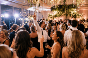 Guests celebrating on a vibrant luxury wedding dance floor with immersive lighting and energetic reception atmosphere