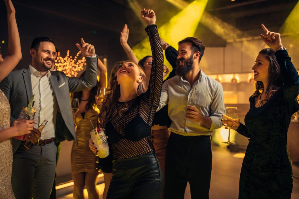 Guests dancing and celebrating during an upscale private party with elegant lighting and high-energy atmosphere.