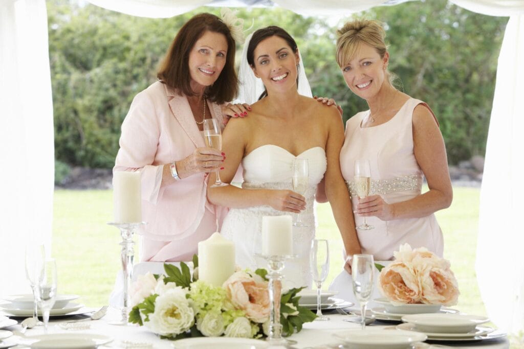 Bride celebrating with mother and grandmother during elegant wedding reception