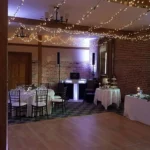 Pillar and Post wedding reception room with warm lighting and entertainment setup by Icon Events.