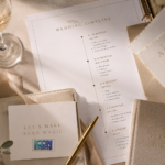 Elegant wedding planning table with stationery, champagne, gold accents and a printed wedding timeline