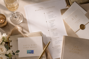 Elegant wedding planning table with stationery, champagne, gold accents and a printed wedding timeline