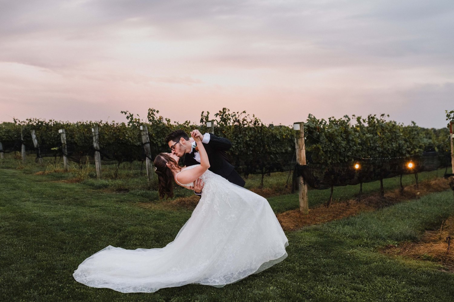 Newlywed couple walking through the vineyard at 180 Estate Winery