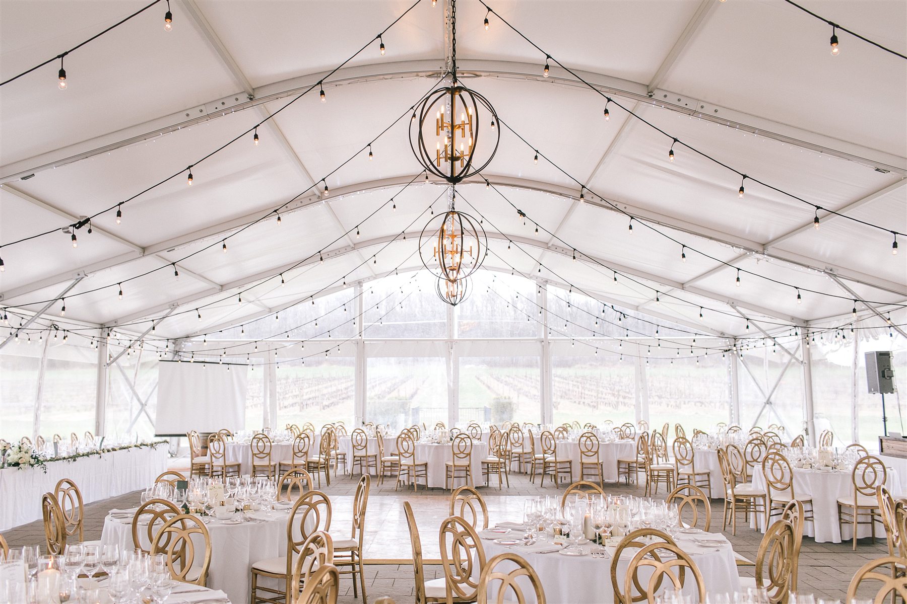 Wedding reception tables beneath the Château des Charmes seasonal tent