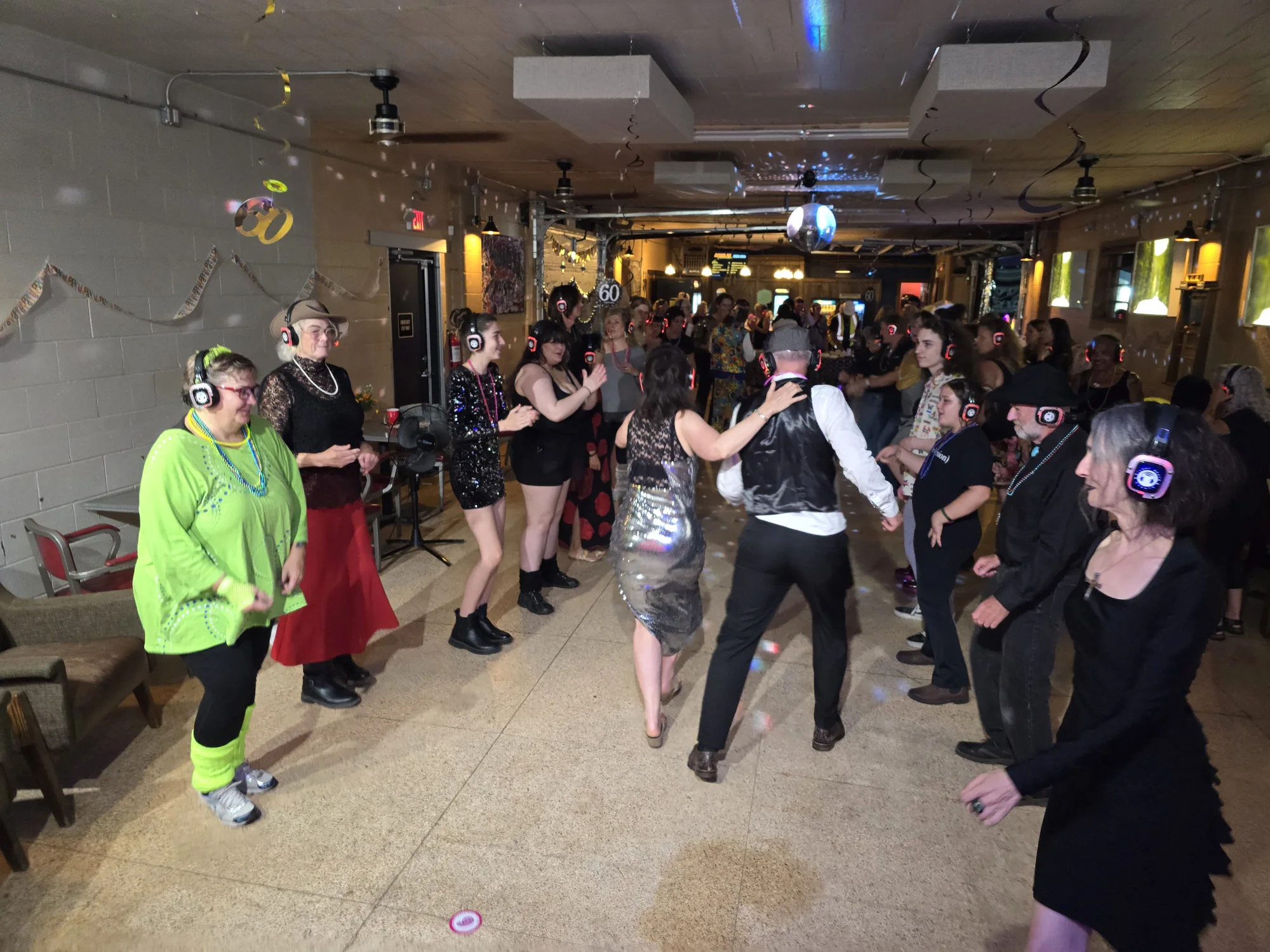 Guests dancing at an Icon Events silent party with glowing wireless headphones