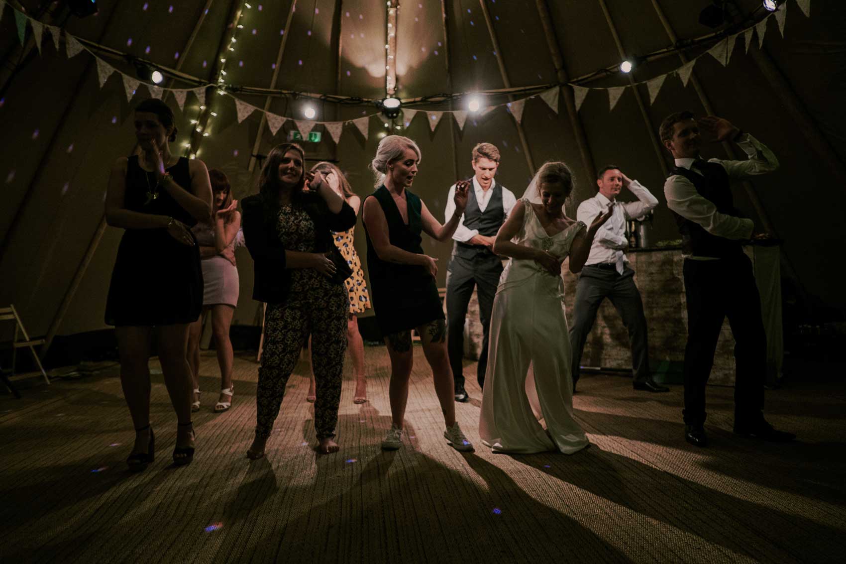 Wedding guests dancing under colourful reception lighting in Niagara