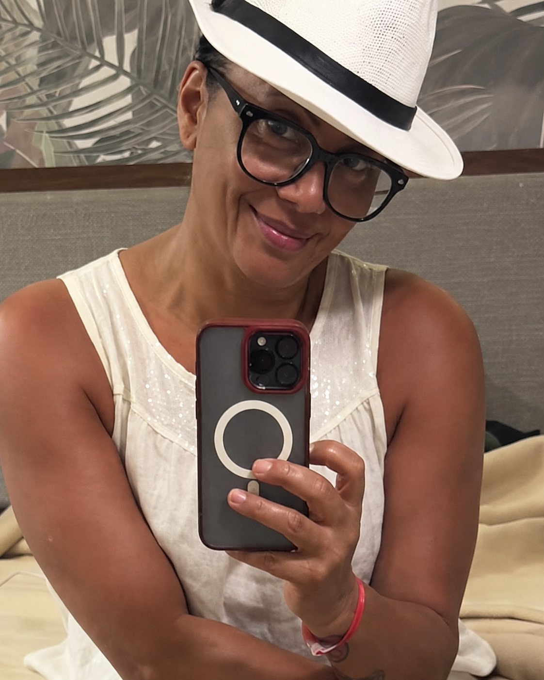 Wendy Wolfe smiling in a white hat and glasses