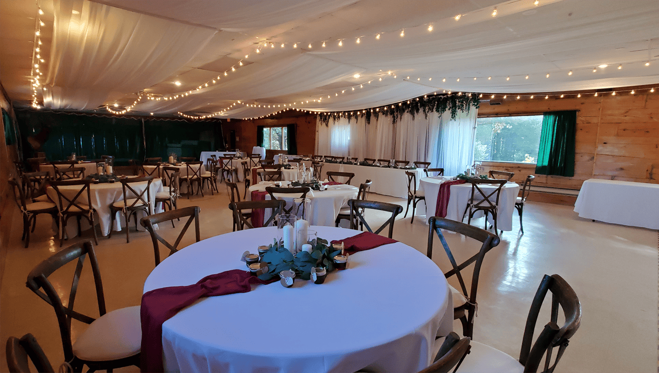 Rustic Bancroft wedding reception room with tables and string lights